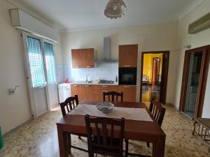 a kitchen with a table and chairs in a room at Appartamento nel salento CASAMALENA in Acquarica del Capo +6 photos