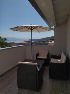 a balcony with chairs and an umbrella on a roof at Apartman Barada in Slatine