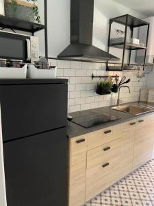a kitchen with a black refrigerator and a sink at El rincón de Elena. in Torre del Mar +7 photos