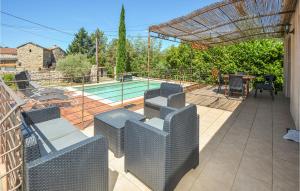 a patio with wicker chairs and a swimming pool at Lovely Home In Bordezac With Wifi in Bordezac