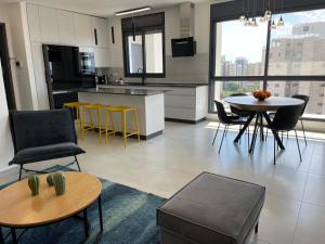 a kitchen and living room with a table and chairs at #דירת יוקרה על הים Sunset Beach Apartment# in Giv‘at Olga
