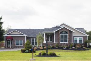 a house with a landscaping in front of it at Clarence Inn Extended Stay in Clarence Center