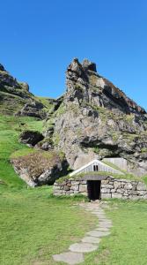 a stone building in front of a rocky mountain at Selfoss Apartment in Selfoss