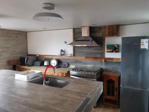 cocina con fregadero y nevera de acero inoxidable en Altavista comodidad modernidad y seguridad, en Ranco