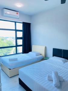 two beds in a room with a window at KEEN Suites-Jesselton Quay in Kota Kinabalu