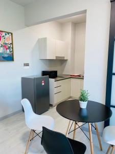a kitchen with a table and chairs and a refrigerator at KEEN Suites-Jesselton Quay in Kota Kinabalu