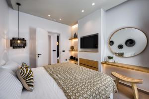 a bedroom with a bed and a mirror and a tv at Anatelo house in Fira