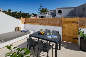 a patio with a table and chairs on a balcony at Anatelo house in Fira
