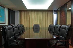 une salle de conférence avec une table et des chaises en bois dans l'établissement International Hotel Sayen, à Irkoutsk