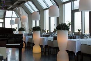 a dining room with tables and chairs and windows at International Hotel Sayen in Irkutsk