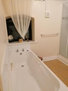 a white bath tub in a bathroom with a window at Barrow mews views in Carlow