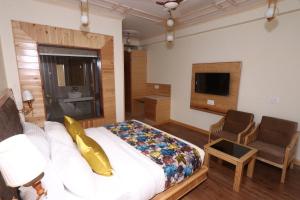 1 dormitorio con 1 cama, 1 sofá y 1 silla en Niranya Guest House, en Katrain