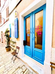 a blue door leading to a room with a blue bench at Apartments La Casa di Loreto in Rovinj