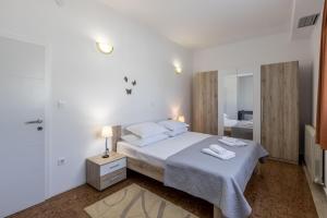 a white bedroom with a bed and a shower at APARTMENTS ANA in Umljanović +76 photos