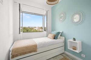 Schlafzimmer mit blauen Wänden und einem Bett mit Fenster in der Unterkunft Ca Nostra Apartment in Cala en Porter