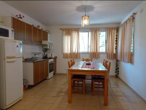 a kitchen with a table with chairs and a refrigerator at Apartamentos Santa Rosa PB 1 in Córdoba