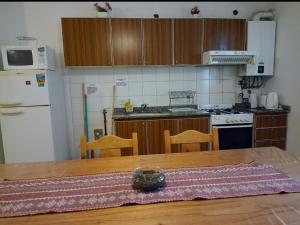 a kitchen with a wooden table and a kitchen with a refrigerator at Apartamentos Santa Rosa PB 1 in Córdoba
