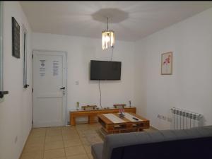 een woonkamer met een bank, een tafel en een tv bij Apartamentos Santa Rosa PB 1 in Cordoba