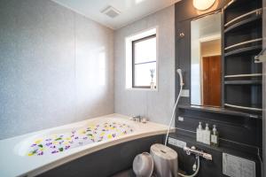 a bathroom with a tub with colorful sprinkles on it at Palm Villa Ishigakijima karei in Ishigaki Island