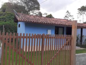 une maison avec une clôture en bois devant elle dans l'établissement Casa Vênus, à São Pedro da Serra