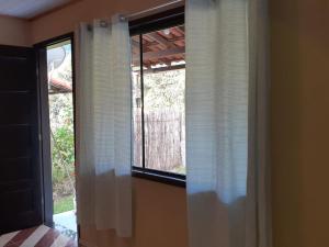 um quarto com uma janela com persianas brancas em Casa Vênus em São Pedro da Serra