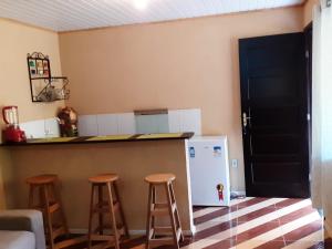 - une cuisine avec deux tabourets et un comptoir avec un réfrigérateur dans l'établissement Casa Vênus, à São Pedro da Serra