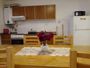 een vaas met bloemen op een tafel in een keuken bij Apartamentos Santa Rosa PB3 in Cordoba +4 foto's
