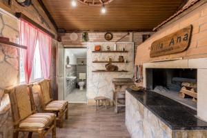 a kitchen with a fireplace and chairs in a room at APARTMENTS ANA in Umljanović