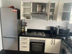 a kitchen with a refrigerator and a stove at Appartement pied dans l eau à Residence Beralmar in Asilah