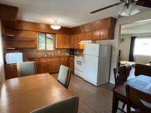 a kitchen with a table and a white refrigerator at Brookside Motel in Golden