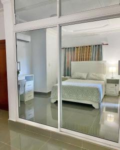 a bedroom with a bed and a large glass window at Complejo Ecoturistico Rancho Cielo in Licey al Medio