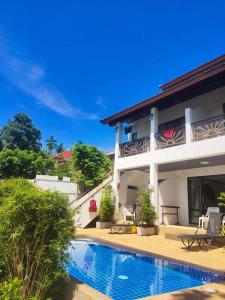 una casa con piscina al lado de un edificio en BEA Privileged Apartment en Lamai Beach