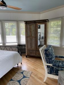 a bedroom with a bed and a chair and a mirror at The Tern Inn Bed & Breakfast and Cottages in West Harwich