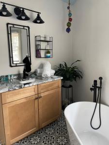 a bathroom with a tub and a sink and a mirror at The Tern Inn Bed & Breakfast and Cottages in West Harwich