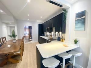 a kitchen and dining room with a table and chairs at Coastline Retreats - Cloud9 Holiday Accommodation- 2 Bedroom self contained garden flat - Luxury bath, Netflix, Superfast Wifi, Parking included in Bournemouth