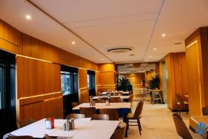 a restaurant with wooden walls and tables and chairs at Hôtel La Perla in Al Hoceïma