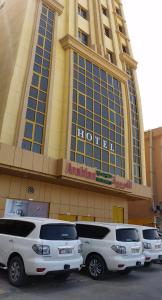 una fila di auto parcheggiate di fronte a un edificio di Arabian Hotel Apartments ad Ajman