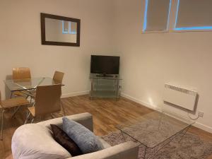 a living room with a couch and a table and a television at Aberdeen stay central 2-bedrooms Apt-No Party in Aberdeen