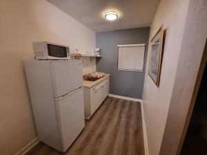 eine kleine Küche mit einem Kühlschrank und einer Mikrowelle in der Unterkunft Stardust Hotel in Miami Beach