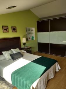 a bedroom with a large bed with a green wall at Casa Vilarousa in Villanueva de Arosa