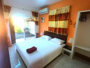 a bedroom with a white bed with a red object on it at Lamai villa in Lamai