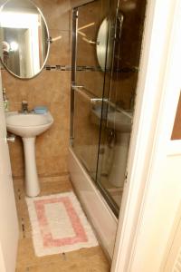 a bathroom with a glass shower and a sink at Private 2 Bedroom Beachfront Penthouse Condo Ocho Rios, Jamaica in Ocho Rios
