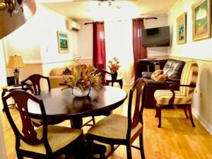 a living room with a table and chairs and a couch at Private 2 Bedroom Beachfront Penthouse Condo Ocho Rios, Jamaica in Ocho Rios