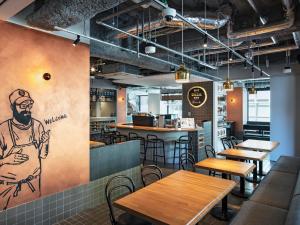 a restaurant with wooden tables and a drawing on the wall at all day place shibuya in Tokyo
