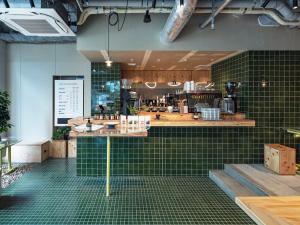 a restaurant with green tiled walls and a counter at all day place shibuya in Tokyo