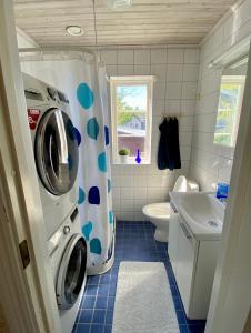 ein kleines Bad mit Waschmaschine und Trockner in der Unterkunft Villa i Norrtälje in Norrtälje