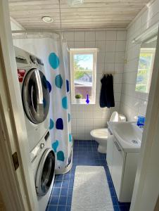 a small bathroom with a washer and dryer in it at Villa i Norrtälje in Norrtälje