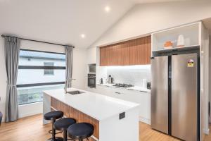 a kitchen with a refrigerator and two stools at Starry Lodge in Lake Tekapo