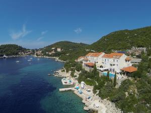 un gruppo di edifici sulla riva di un corpo idrico di Hotel Bozica Dubrovnik Islands a Suđurađ