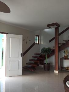 Habitación con puerta blanca y escaleras de madera en Pousada Villa Mares en São Pedro da Aldeia